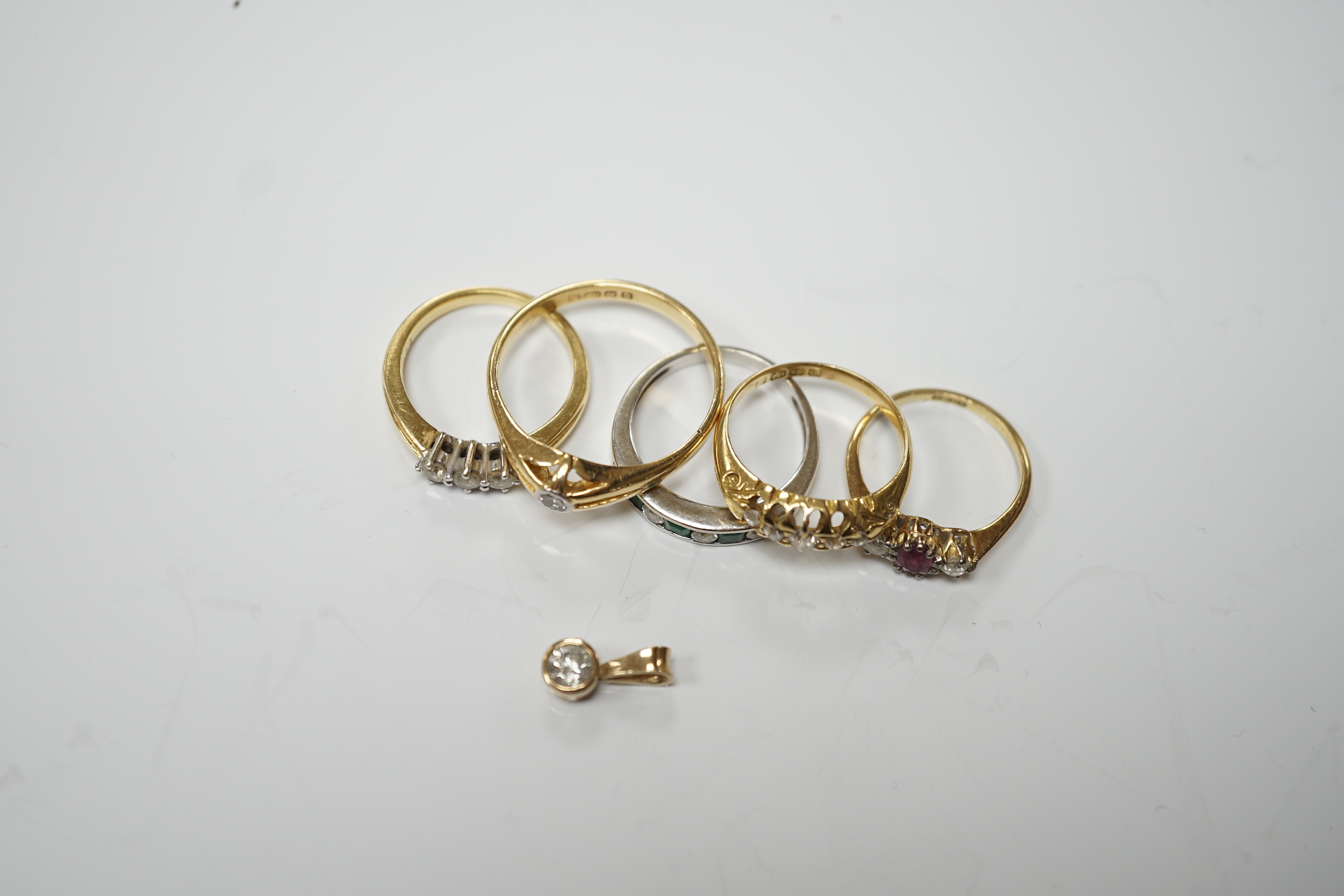 Four assorted early 20th century and later 18ct and gem set rings, including solitaire diamond and three stone diamond, gross 14.6 grams, together with a white metal and channel set emerald and diamond half hoop ring and